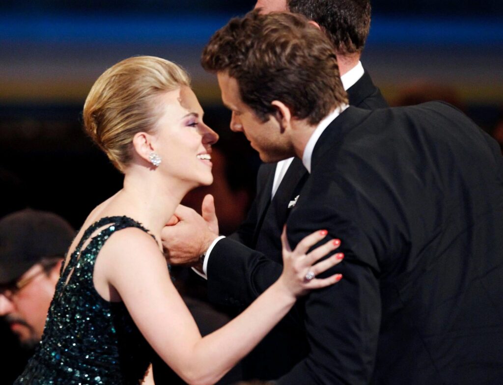 Ryan Reynolds and Scarlett Johansson initiating a kiss