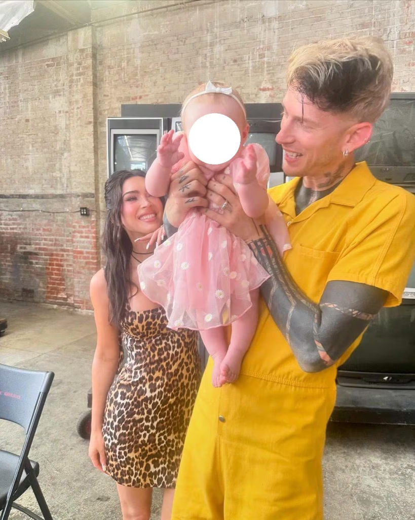 Megan Fox and MGK holding their daughter