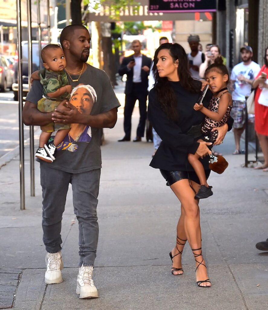 Kim Kardashian and Kanye West holding their kids