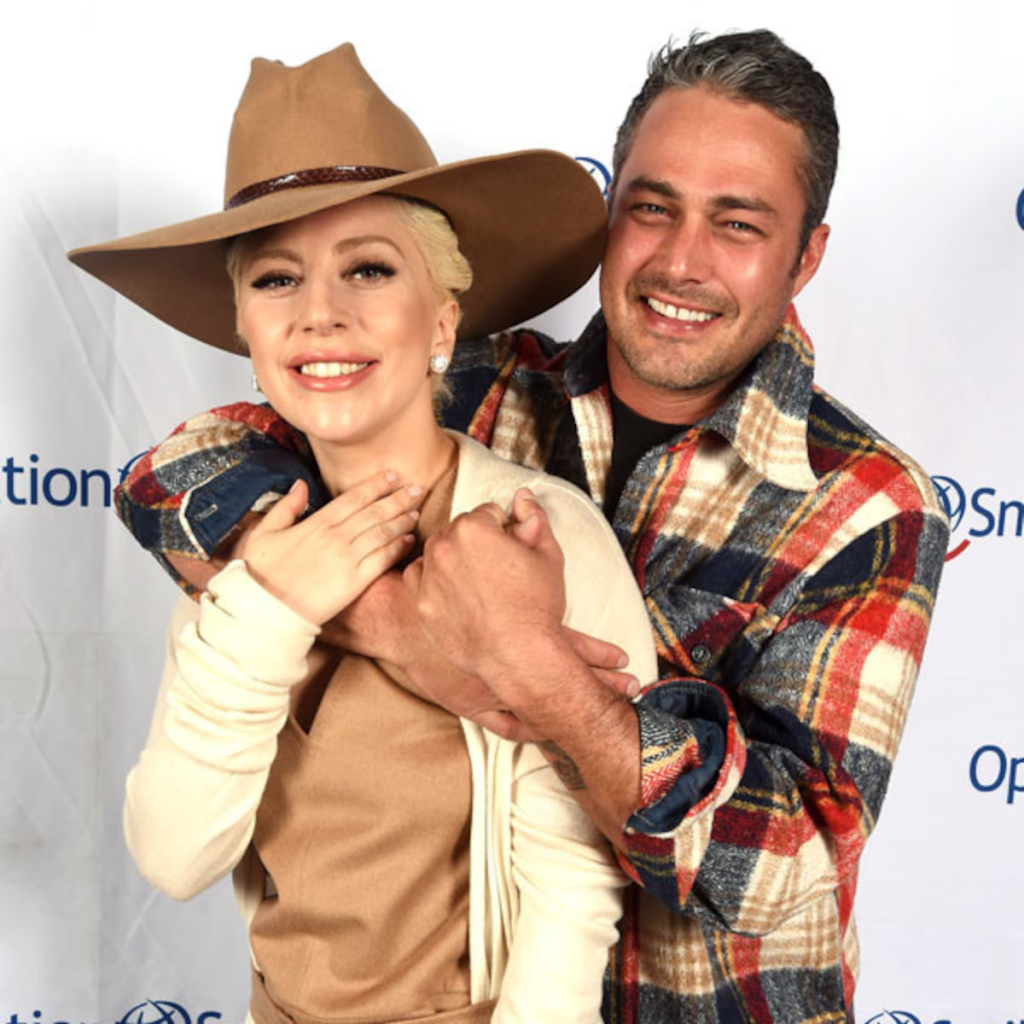 Lady Gaga and Taylor Kinney hugging at an event