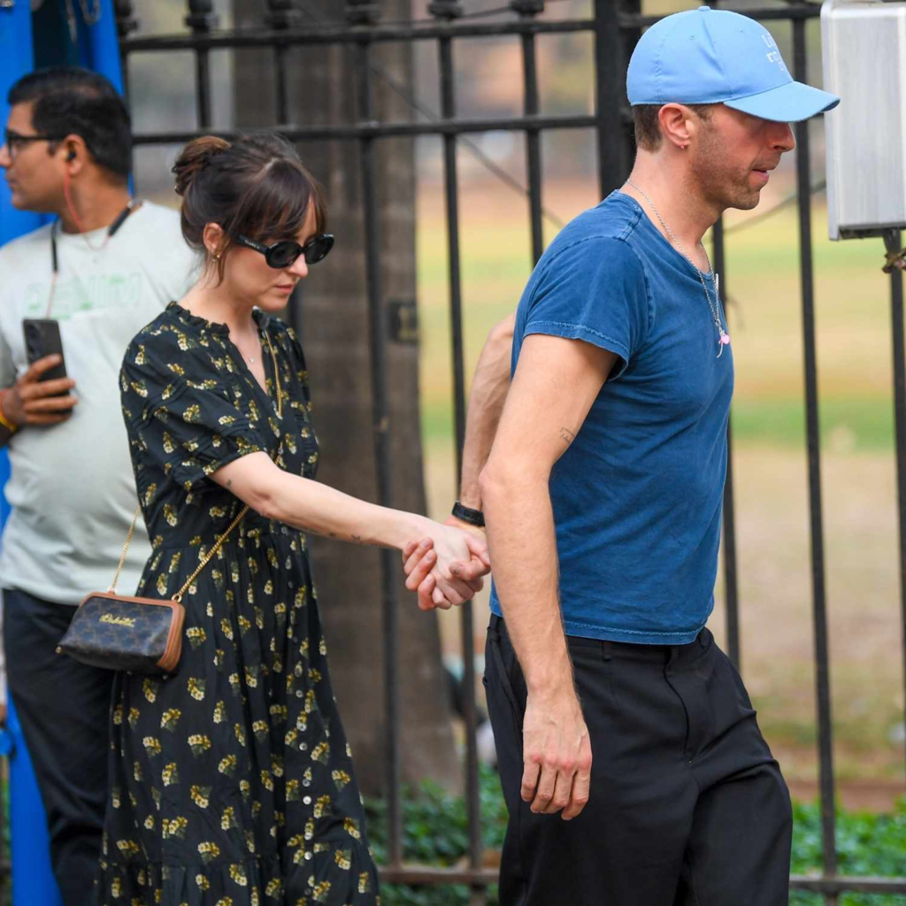 Chris Martin and Dakota Johnson holding hands